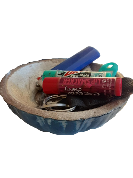 silver and dark blue dish with lip balms, a lighter, and keys