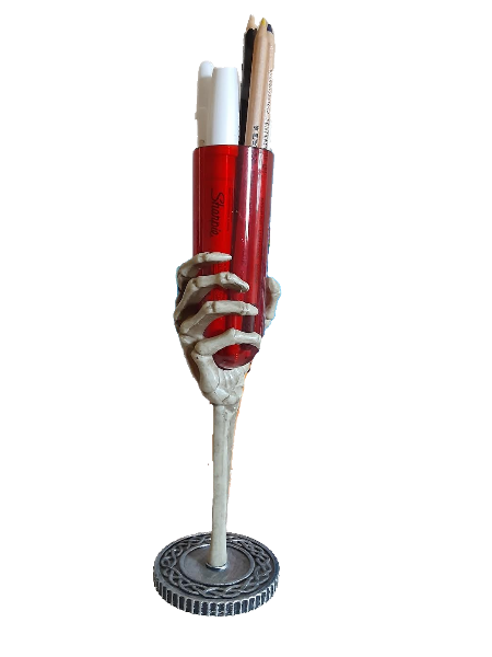 red plastic goblet held in a skeleton hand with pens in it